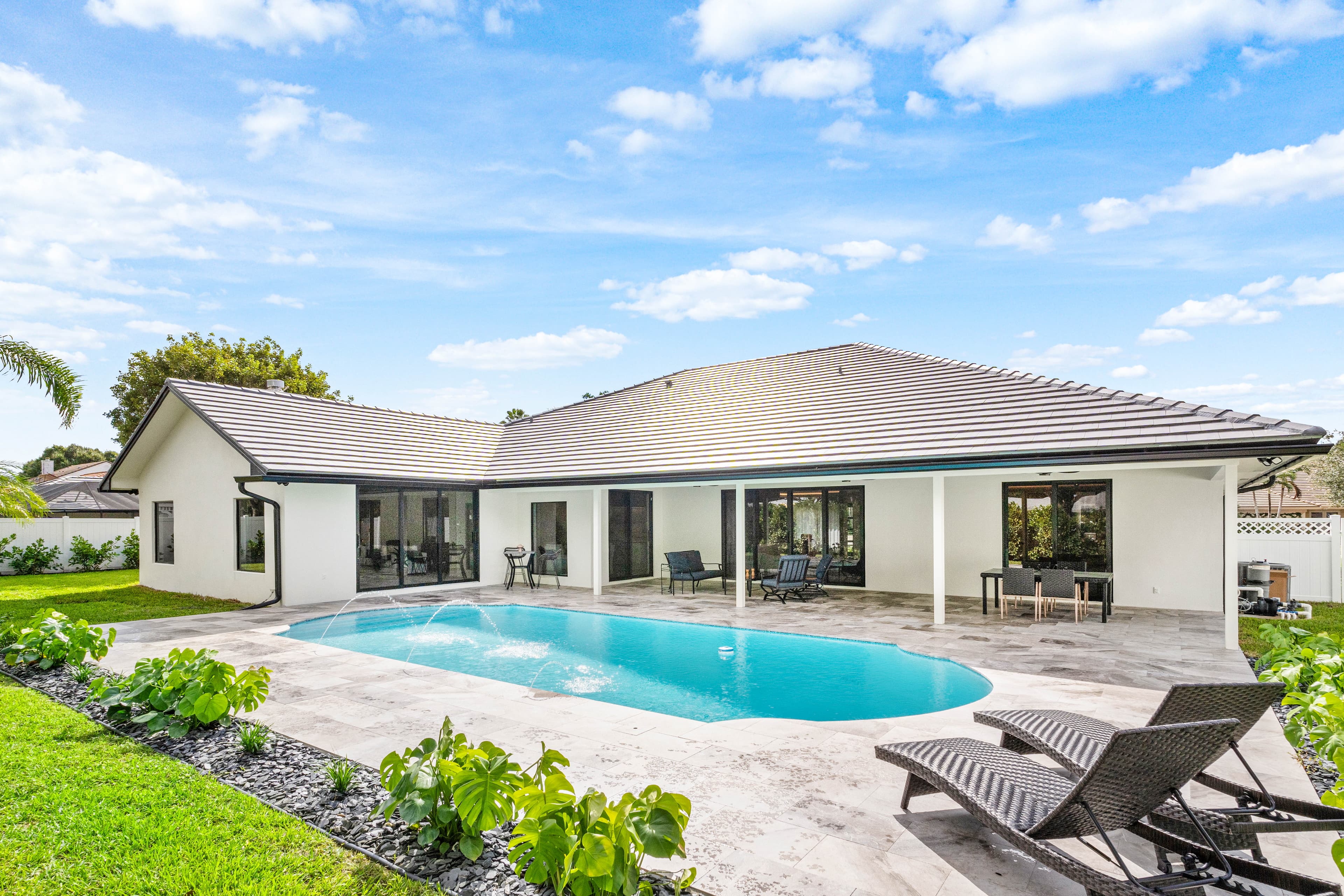 Pool home exterior with impact sliding glass doors across rear
