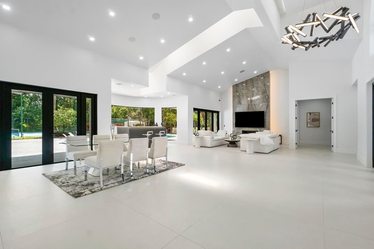 Living room with floor-to-ceiling impact sliding glass doors to pool